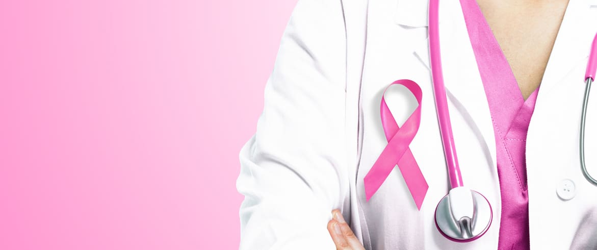 Healthcare professional in a white coat with a pink ribbon symbolizing cancer awareness and a stethoscope, against a soft pink background.